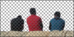 Men behind a fence